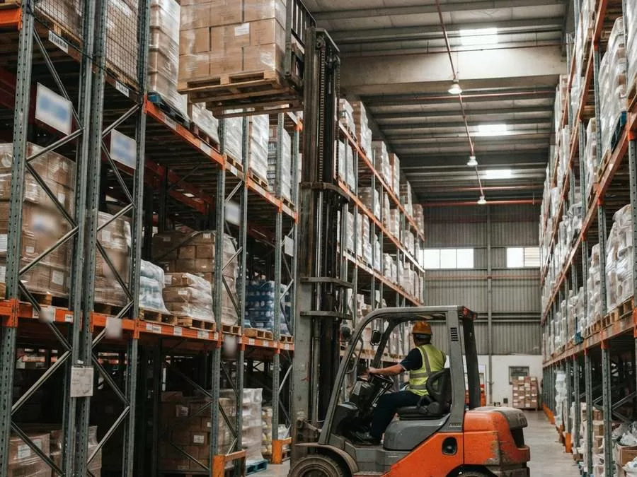 Xe nâng khung 3 tầng đặt pallet lên kệ racking cao trong kho tại Xe Nâng Đức Anh