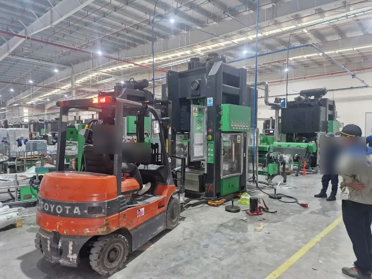 Xe nâng điện Toyota hỗ trợ đội thợ di dời máy dập vào dây chuyền trong nhà xưởng tại Xe Nâng Đức Anh