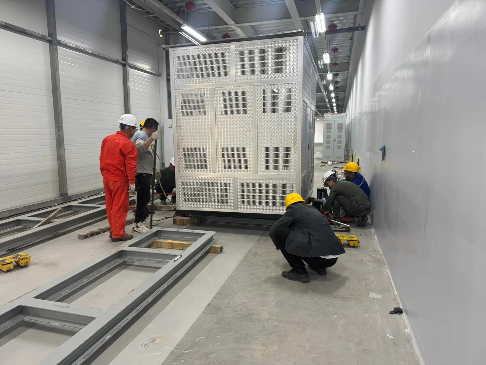 Đội thợ di dời máy biến áp khô dọc hành lang phòng điện nhà máy bằng con lăn tại Xe Nâng Đức Anh