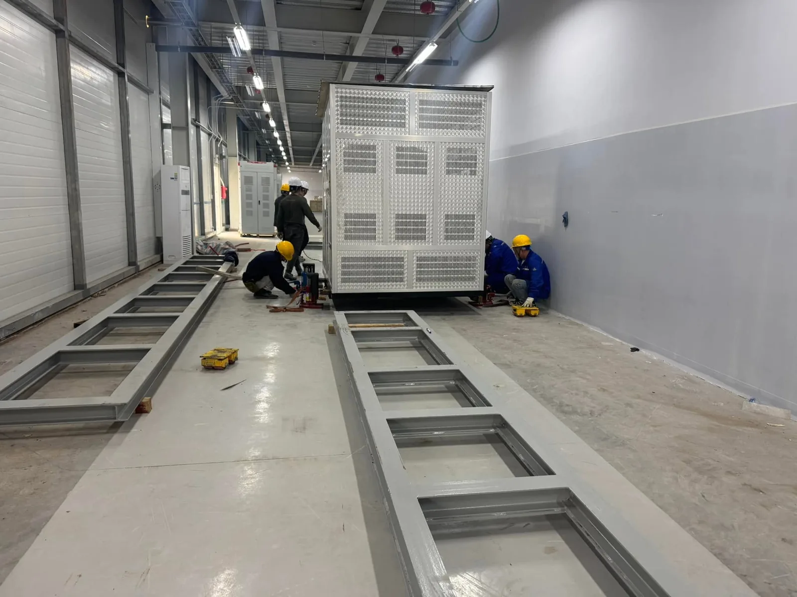 Máy biến áp khô được đưa tới gần bệ thép đặt sẵn trên sàn phòng điện tại Xe Nâng Đức Anh