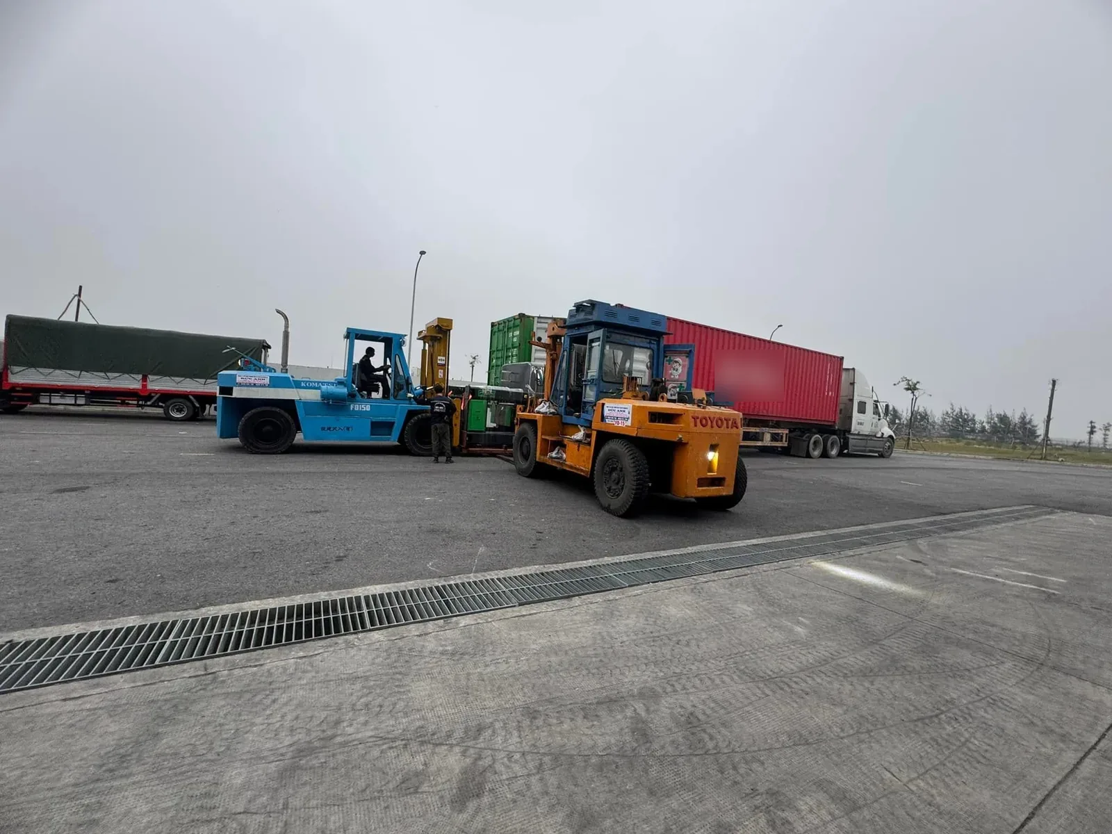 Xe nâng 15 tấn rút kiện máy khỏi container trên bãi rộng có rãnh thoát nước tại Xe Nâng Đức Anh