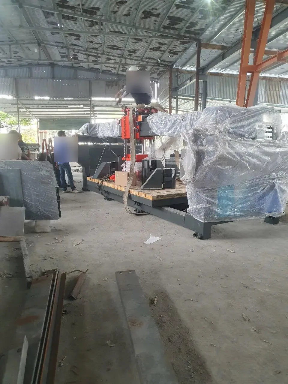 Máy cắt đá lớn đặt trên bệ gỗ trong xưởng đá chật tấm đá tại Xe Nâng Đức Anh