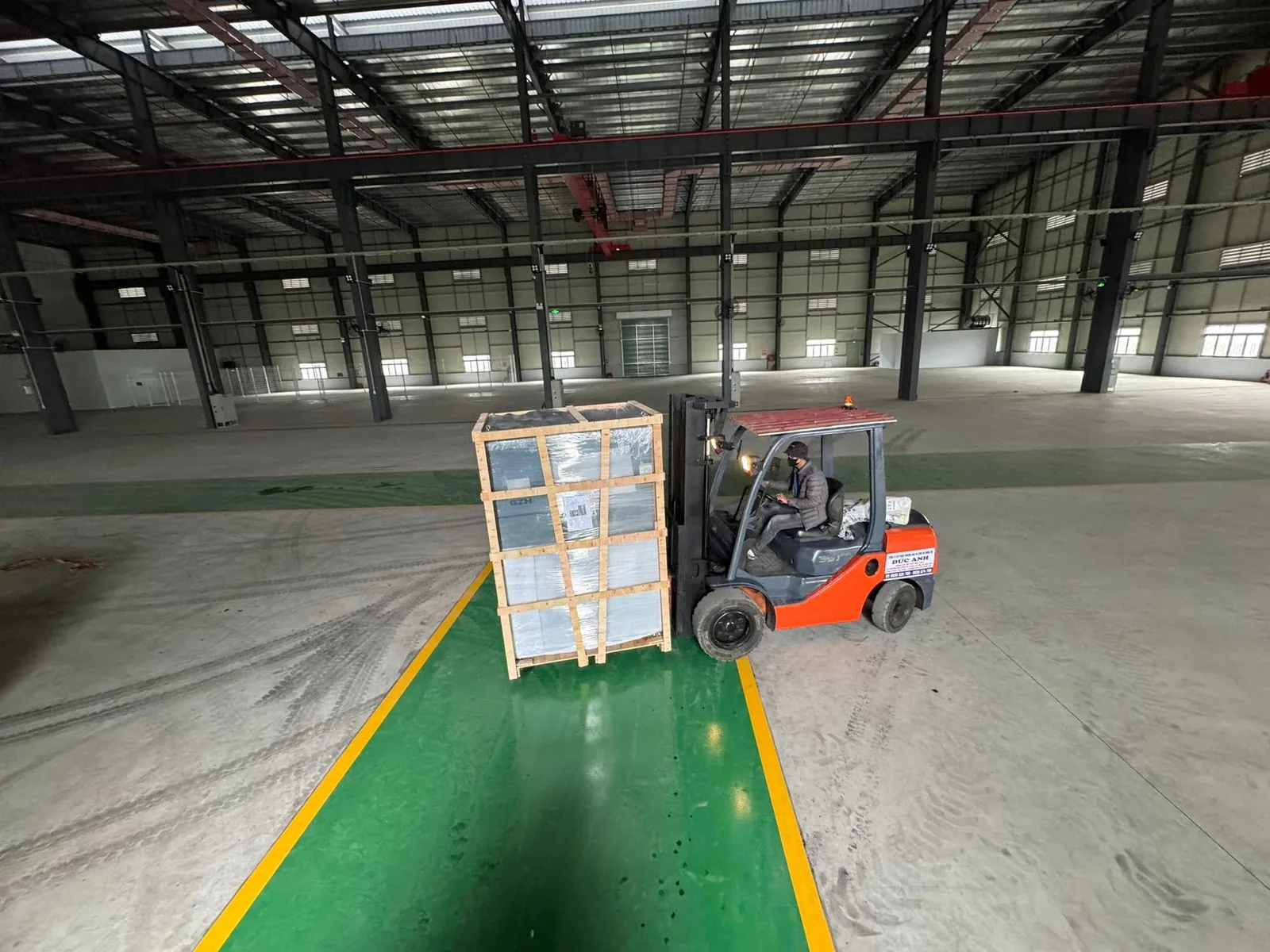 Xe nâng dầu 3 tấn chở kiện kính đóng khung gỗ trong nhà xưởng khung thép tại Xe Nâng Đức Anh