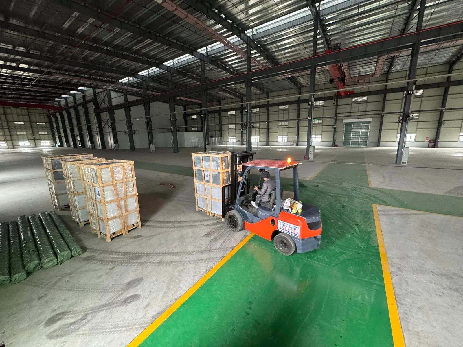 Xe nâng thuê 3 tấn chạy chậm với kiện kính trên vạch phân làn sàn epoxy tại Xe Nâng Đức Anh