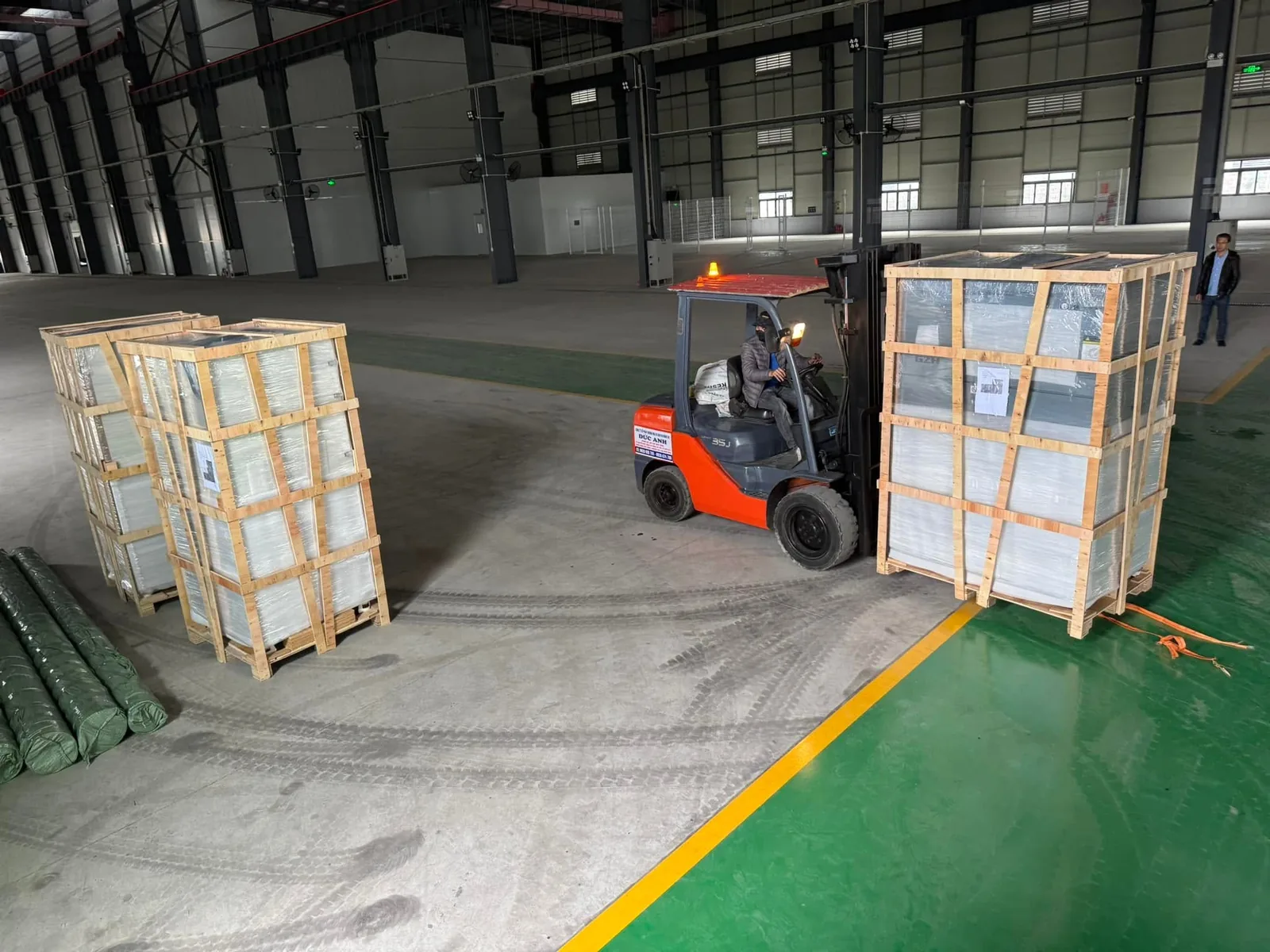 Xe nâng 3 tấn đặt kiện kính cạnh các kiện đã xếp trong kho tại Xe Nâng Đức Anh