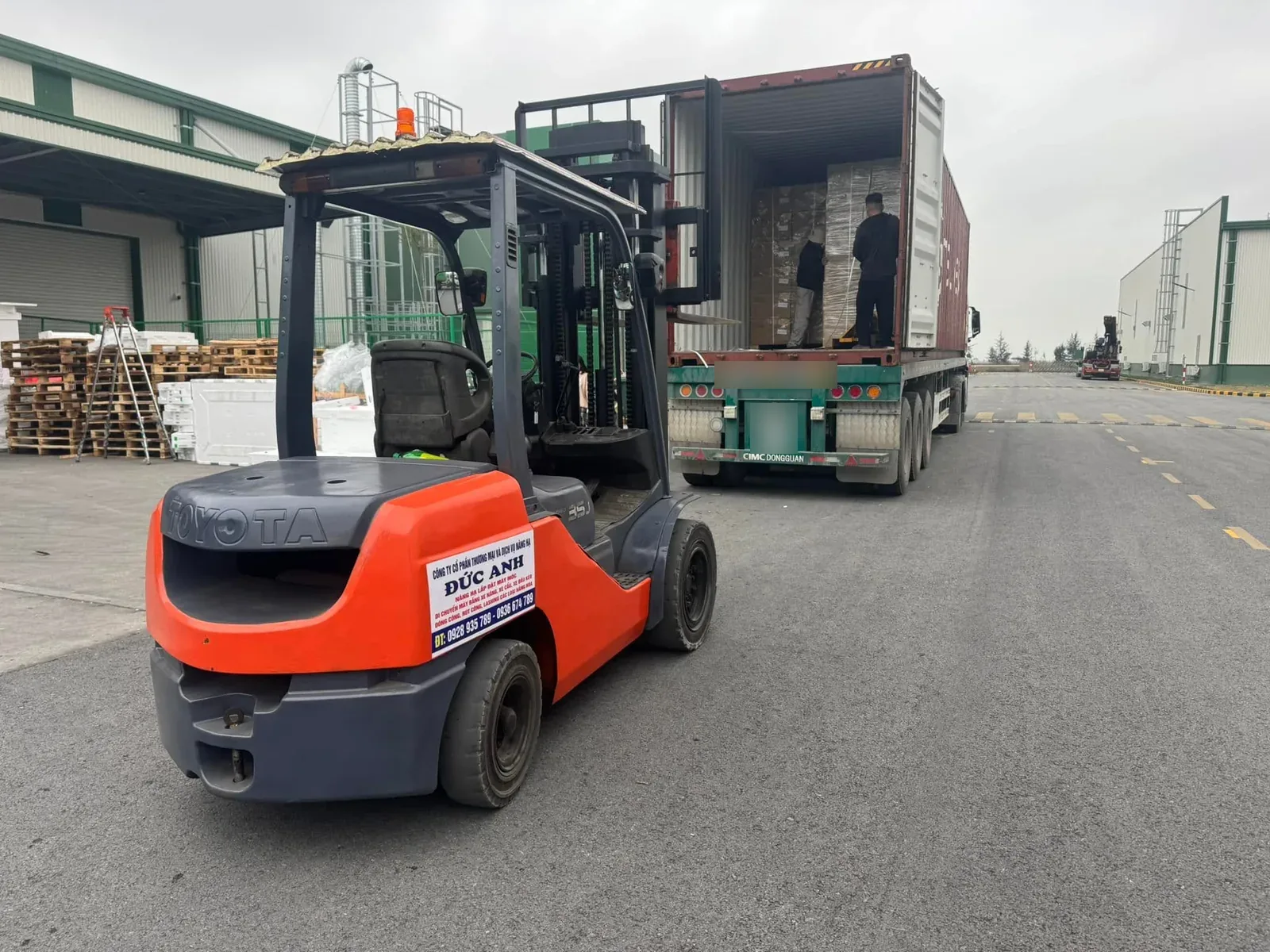 Xe nâng dầu 3 tấn đưa pallet hàng ra khỏi container đỗ sau xe đầu kéo tại Xe Nâng Đức Anh
