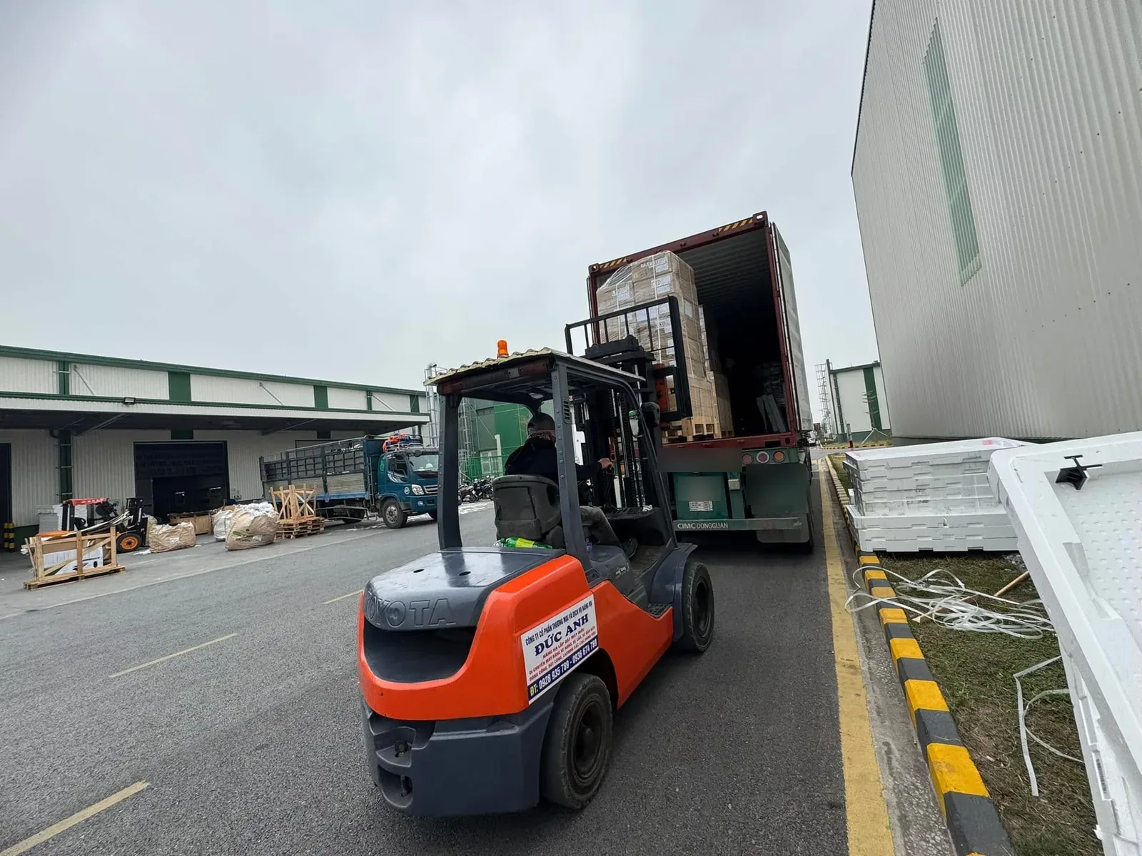 Xe nâng dầu nâng pallet carton ra khỏi container khi rút hàng container tại Xe Nâng Đức Anh