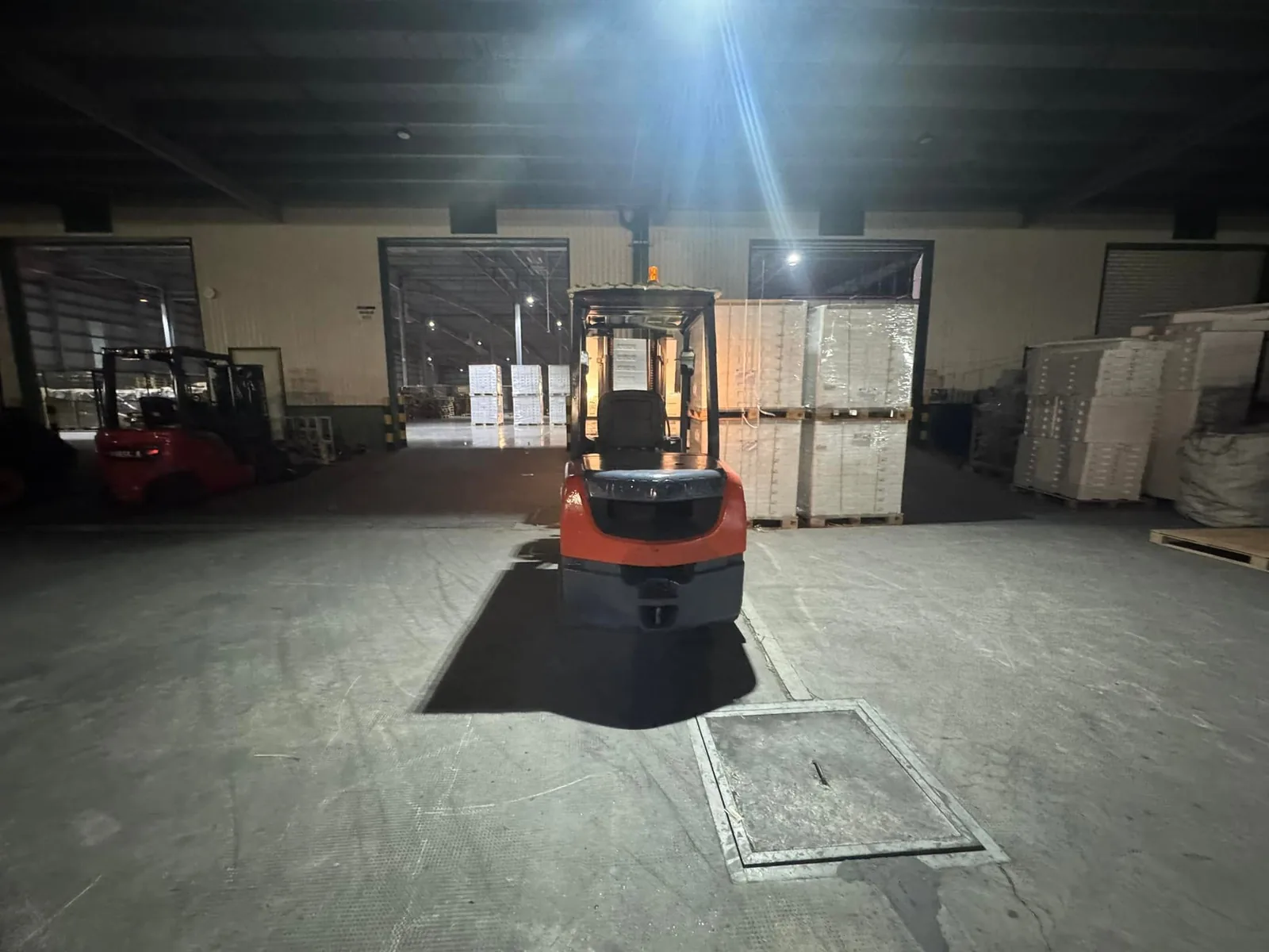Xe nâng làm việc ca đêm trong kho nhà máy với hàng pallet xếp sẵn tại Xe Nâng Đức Anh