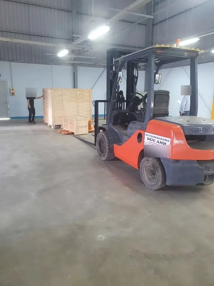 Xe nâng chuẩn bị di chuyển kiện máy đóng thùng gỗ trong nhà xưởng điện tử tại Hải Phòng