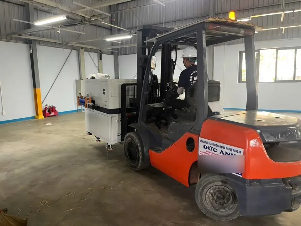 Xe nâng dầu 3 tấn chở máy dây chuyền đi chậm trên nền xưởng sạch tại Xe Nâng Đức Anh