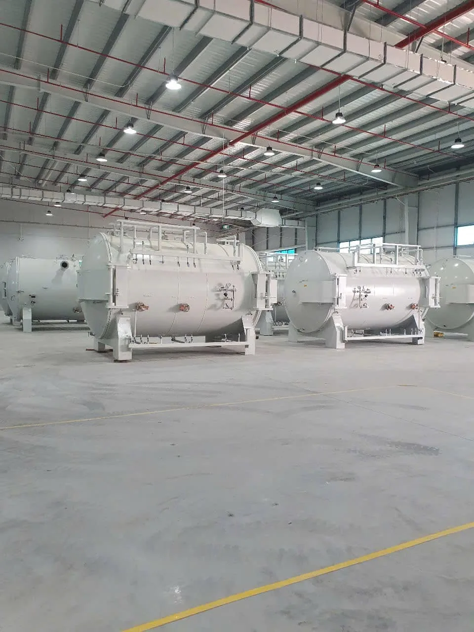 Hàng bồn áp lực nằm ngang đặt trên chân đỡ trong nhà xưởng rộng tại Xe Nâng Đức Anh